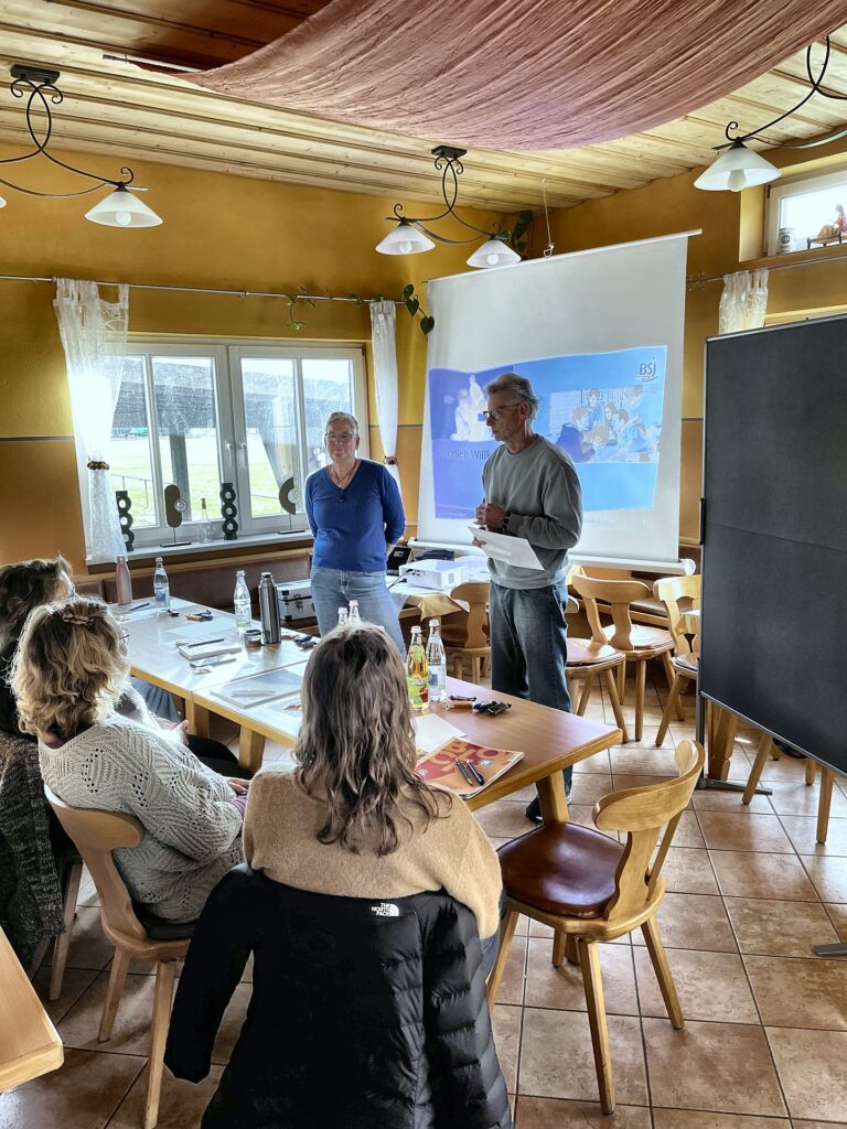 Zwei Referenten stehen bei der Schulung des DJK Furth vor der Leinwand, im Vordergrund sitzen Teilnehmende